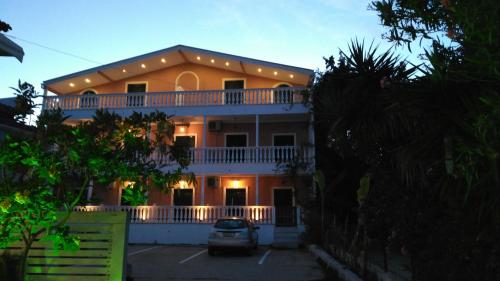 a large house with a car parked in front of it at Infinity blue beach apartments in Tsilivi