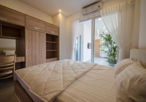 a bedroom with a large bed and a desk at Minh Apartment in Danang