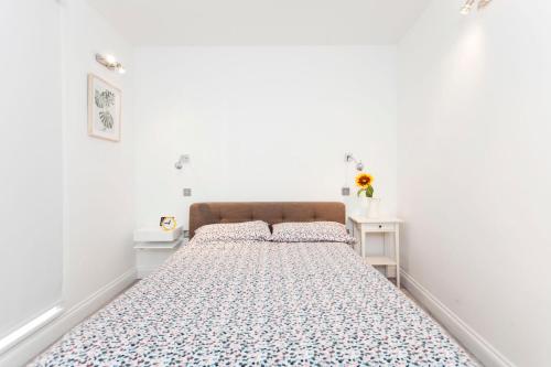 un grande letto in una stanza con pareti bianche di Italianflat - Stamford Bridge a Londra