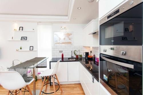 een keuken met witte kasten en een zwarte oven bij Italianflat - Stamford Bridge in Londen