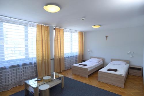 a hotel room with two beds and a table at Dobre Miejsce Dom Rekolekcyjny in Warsaw