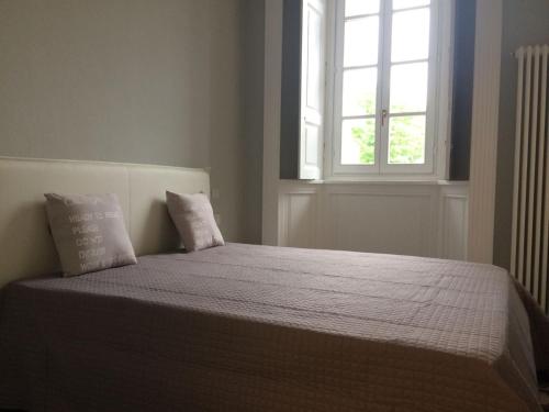 1 cama con 2 almohadas en un dormitorio con ventana en Garibaldi 1, en Angera