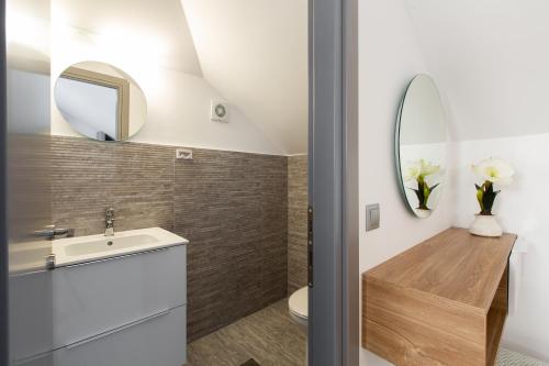 a bathroom with a sink and a mirror at Saint Lucas Suites in Nea Potidaea