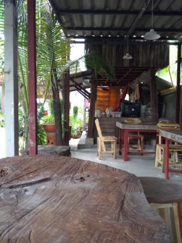 a room with a wooden table and tables and chairs at Chom Chan Guesthouse & Hostel in Chiang Mai