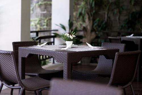 a table with chairs and a vase of flowers on it at Residencia Boracay in Boracay