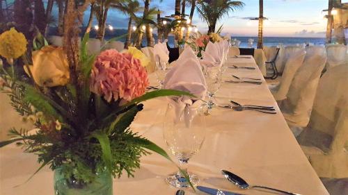 a long table with glasses and flowers on it at Residencia Boracay in Boracay