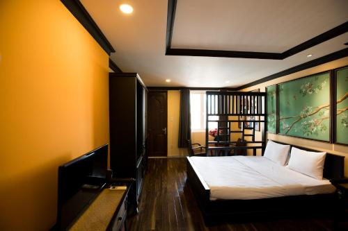 1 dormitorio con 1 cama y una gran pintura en la pared en Ipeace Hotel - Bùi Viện Walking Street en Ho Chi Minh