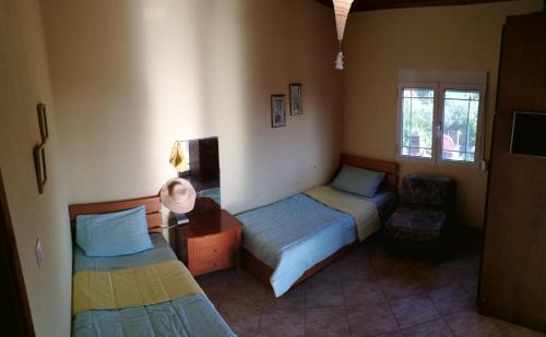 Habitación con 2 camas, escritorio y ventana. en Kavouri 2 en Nea Potidaea