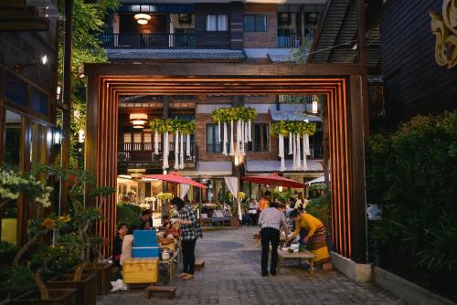 un grupo de personas caminando por una calle en Sunny V Hotel en Chiang Mai