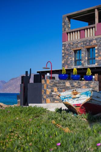 a boat sitting on the grass in front of a building at Villa Menelaos in Mochlos
