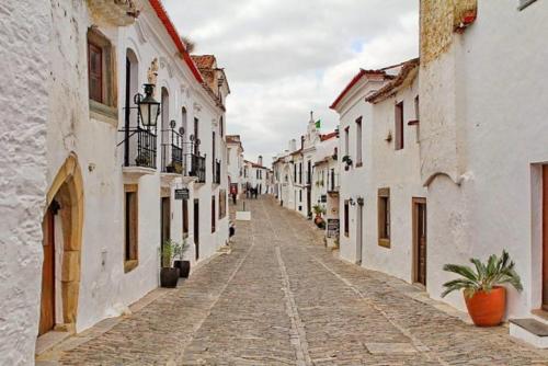 a cobblestone street in a town with white buildings at Casa da tia Bina in Monsaraz