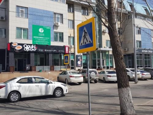 a street with cars parked in front of buildings at Гостиница "Алтын Орда" in Astana