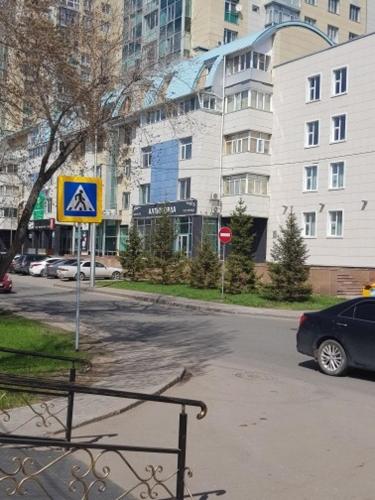 a street with a blue sign on the side of the road at Гостиница "Алтын Орда" in Astana