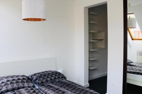 um quarto com um sofá e um espelho em Rozmaring Apartman Pécs em Pécs