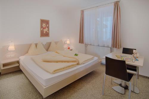 a bedroom with a bed and a desk and a chair at Pension Christl in Caldaro