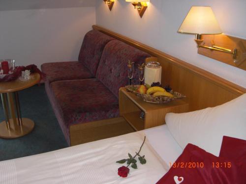 a hotel room with a couch and a bowl of fruit at Hotel Sonneck in Schwäbisch Hall