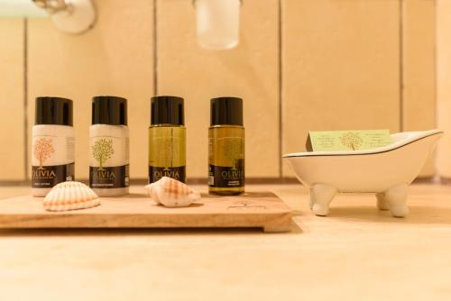 a group of four bottles of essential oils next to a sink at Sunset Studio in Hydra