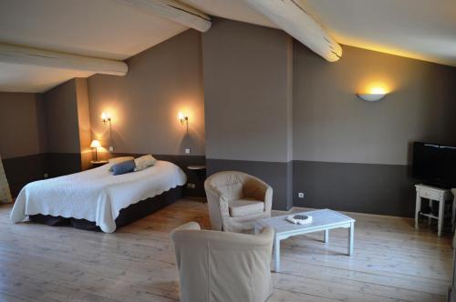 a hotel room with a bed and a table and chairs at Le Couvent in Apt