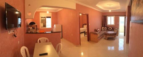 una gran sala de estar con paredes de color naranja y una cocina. en Mirleft Trip, en Mirleft