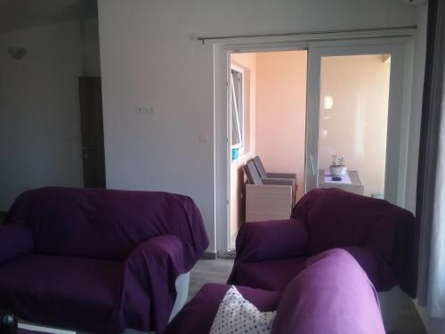 a living room with a purple couch and a window at Apartment Willy in Komiža
