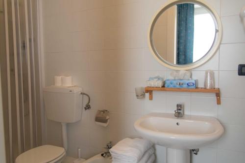 łazienka z umywalką, toaletą i lustrem w obiekcie Hotel Elisabetta w mieście Sestri Levante
