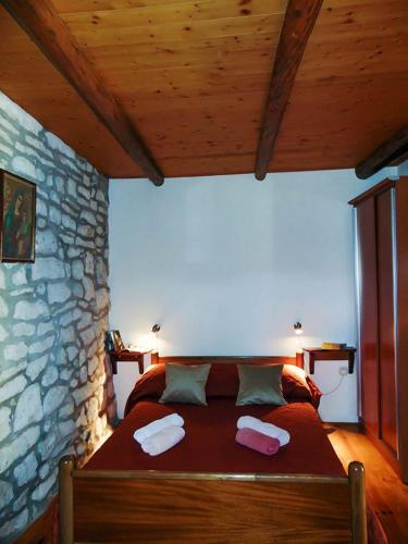 a bedroom with a large bed in a stone wall at Mario (RADE) in Korčula
