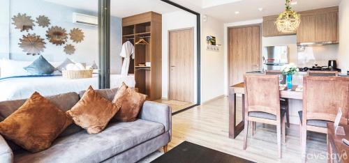 a living room with a couch and a kitchen at Rain Cha-am Huahin By Sake in Cha Am