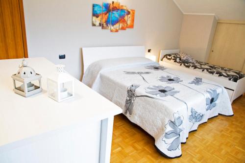 Dormitorio blanco con cama y mesa en Casa Moiser en Tresenda