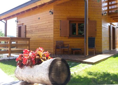 a log vase with flowers in front of a house at B&B Lo Chalet Di Ocre in San Felice dʼOcre