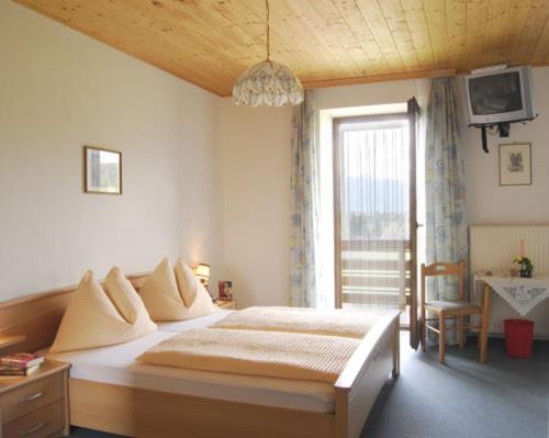 Un dormitorio con una cama grande y una ventana en Pension Guggenbichler, en Seeboden