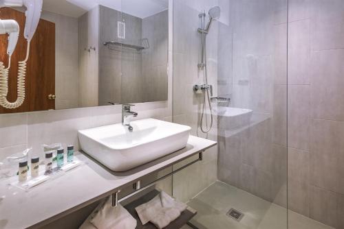 y baño blanco con lavabo y ducha. en 4R Salou Park Resort I, en Salou