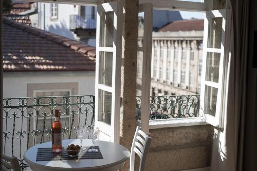 a table and chairs on a balcony with a window at Casas do Loureiro in Porto