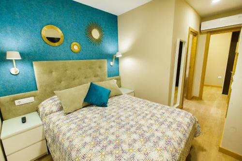 a bedroom with a bed and a blue wall at Hospedería Castilla Plaza Mayor in Ciudad-Rodrigo