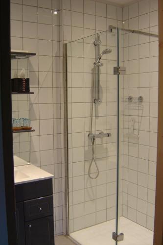a shower with a glass door in a bathroom at Notre Cachette in Biffontaine