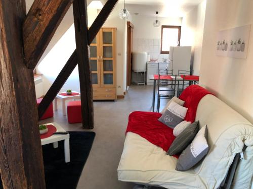 - un salon avec un canapé blanc et une couverture rouge dans l'établissement Duplex à Ribeauvillé, à Ribeauvillé