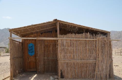 a small wooden building with a blue sign on it at SakraTah Camp - eco friendly in Taba
