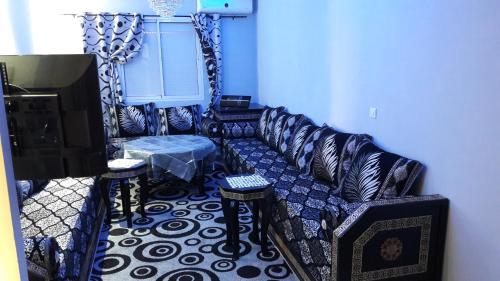 una sala de estar con un sofá y una mesa en Dar Diafa, en Agadir