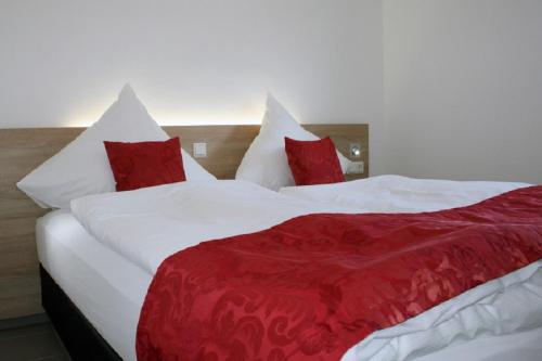 ビューズムにあるdat witte hus 1のベッドルーム1室(ベッド2台、赤と白の枕付)