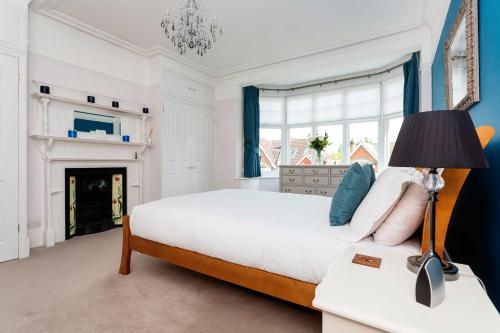 ロンドンにあるVeeve - Vineyard Hill Roadのベッドルーム(大型ベッド1台、暖炉付)