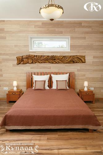 a bedroom with a large bed and two night stands at Hotel Complex Kupava in Podvorki