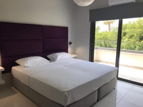 a bedroom with a large bed with a large window at Mare Monte Seaview Boutique Apartment in Paphos