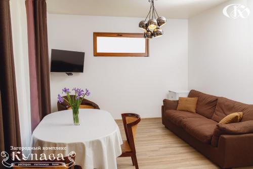 a living room with a table and a couch at Hotel Complex Kupava in Podvorki