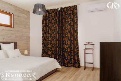 a bedroom with a bed and a black curtain at Hotel Complex Kupava in Podvorki