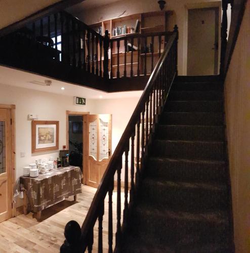 a staircase in a living room with a table at Aras Ghleann Cholm Cille in Glencolumbkille