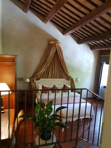 a bedroom with a bed with a canopy at I giardini segreti di Villa Marcello Marinelli in Cison di Valmarino