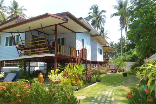 a house with a balcony and a yard at Boons Bungalow Ban Krut in Ban Krut