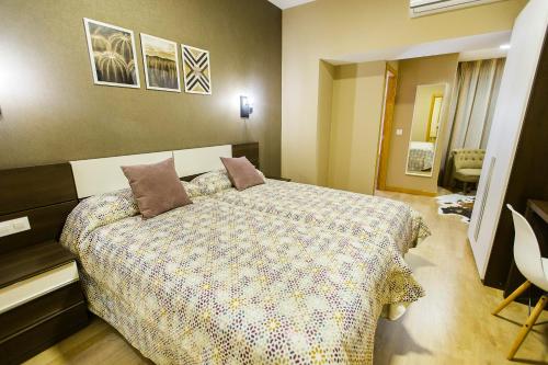 a bedroom with a large bed with pillows on it at Hospedería Castilla Plaza Mayor in Ciudad-Rodrigo