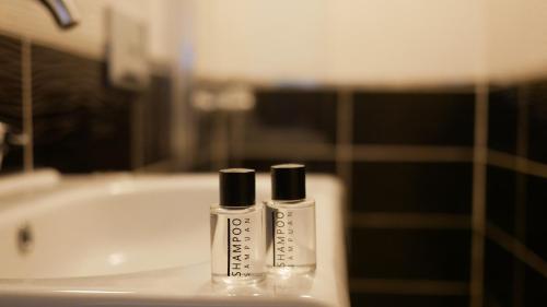 two bottles ofodorizers sitting next to a bath tub at Lena Central Flats in Bursa