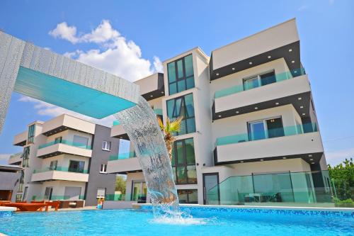 a swimming pool with a fountain in front of a building at Boutique Apartments Ad Astra in Bibinje