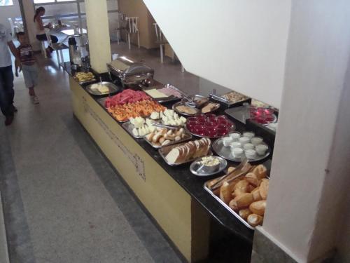 una línea de buffet con muchos tipos diferentes de comida en Goias Hotel en Goiânia